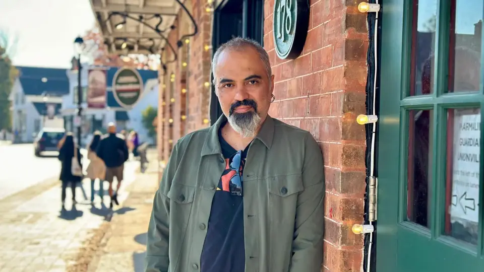 Ahmet Dogan leaning against a brick storefront on a street in Unionville, Markham