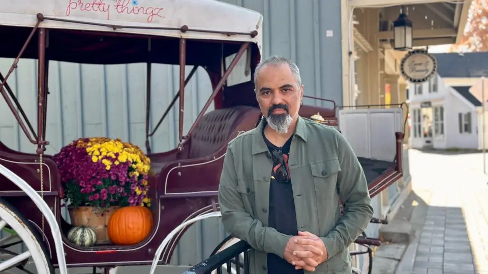 Ahmet Dogan beside a horse carriage decorated with autumn mums and pumpkins in Unionville, Markham