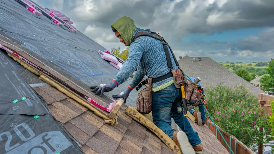 Roofer installing asphalt shingles on a residential roof