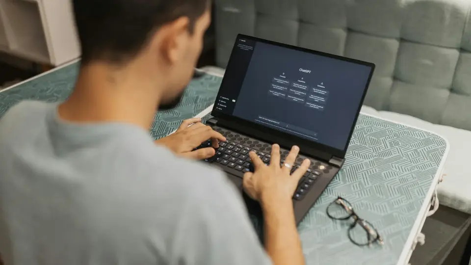 Person typing a question into ChatGPT on a laptop
