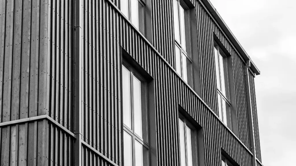 Modern building facade with vertical ribbed metal cladding and tall industrial windows