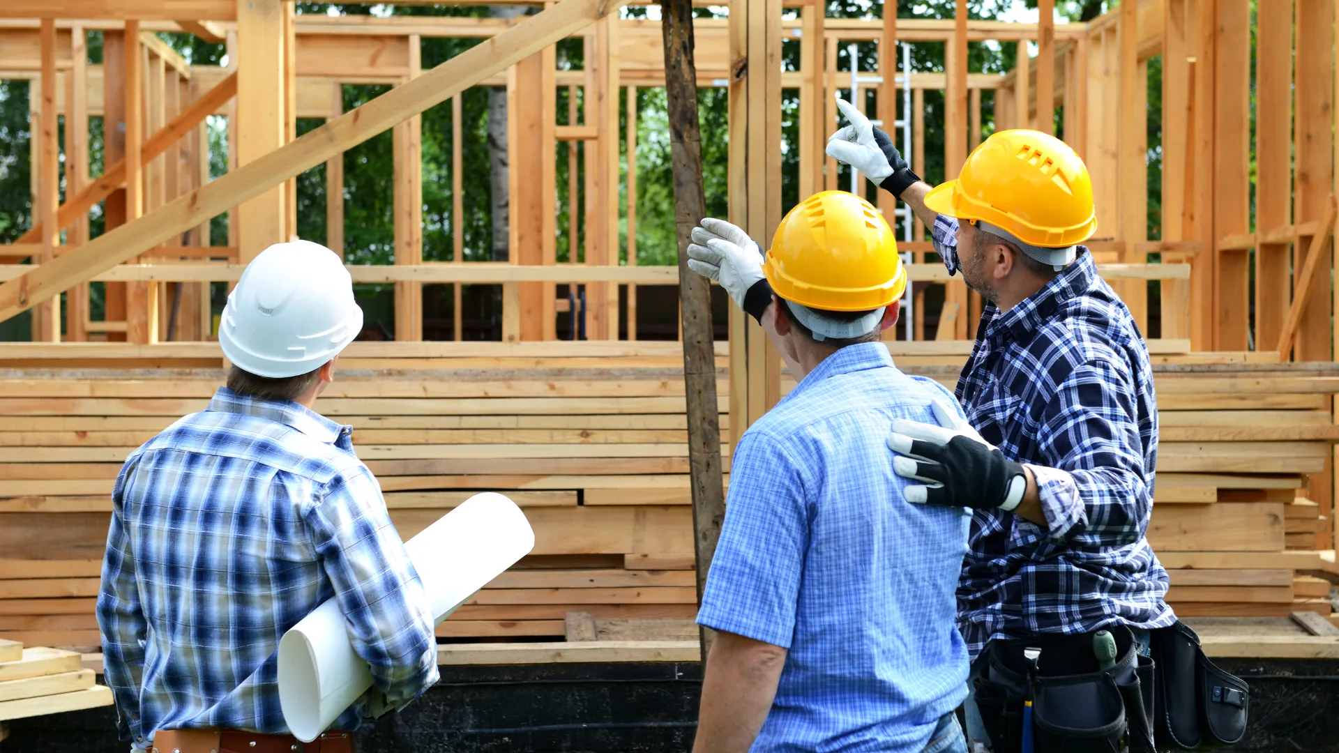 A crew reviews the wood frame of a building under construction