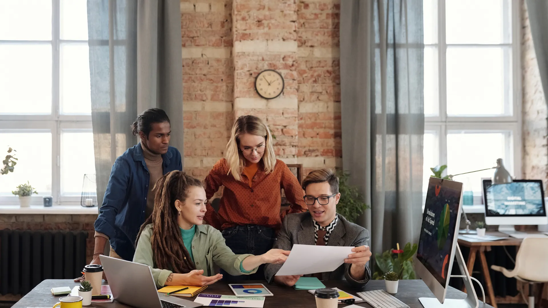 A team compares a printed report with project numbers on a screen