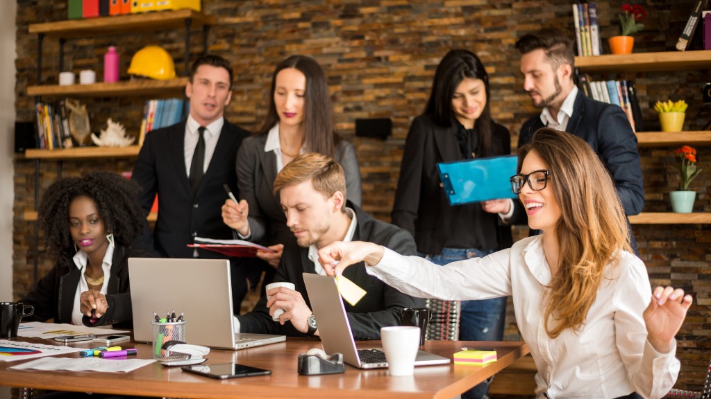 A marketing team reviews laptops and notes around a conference table