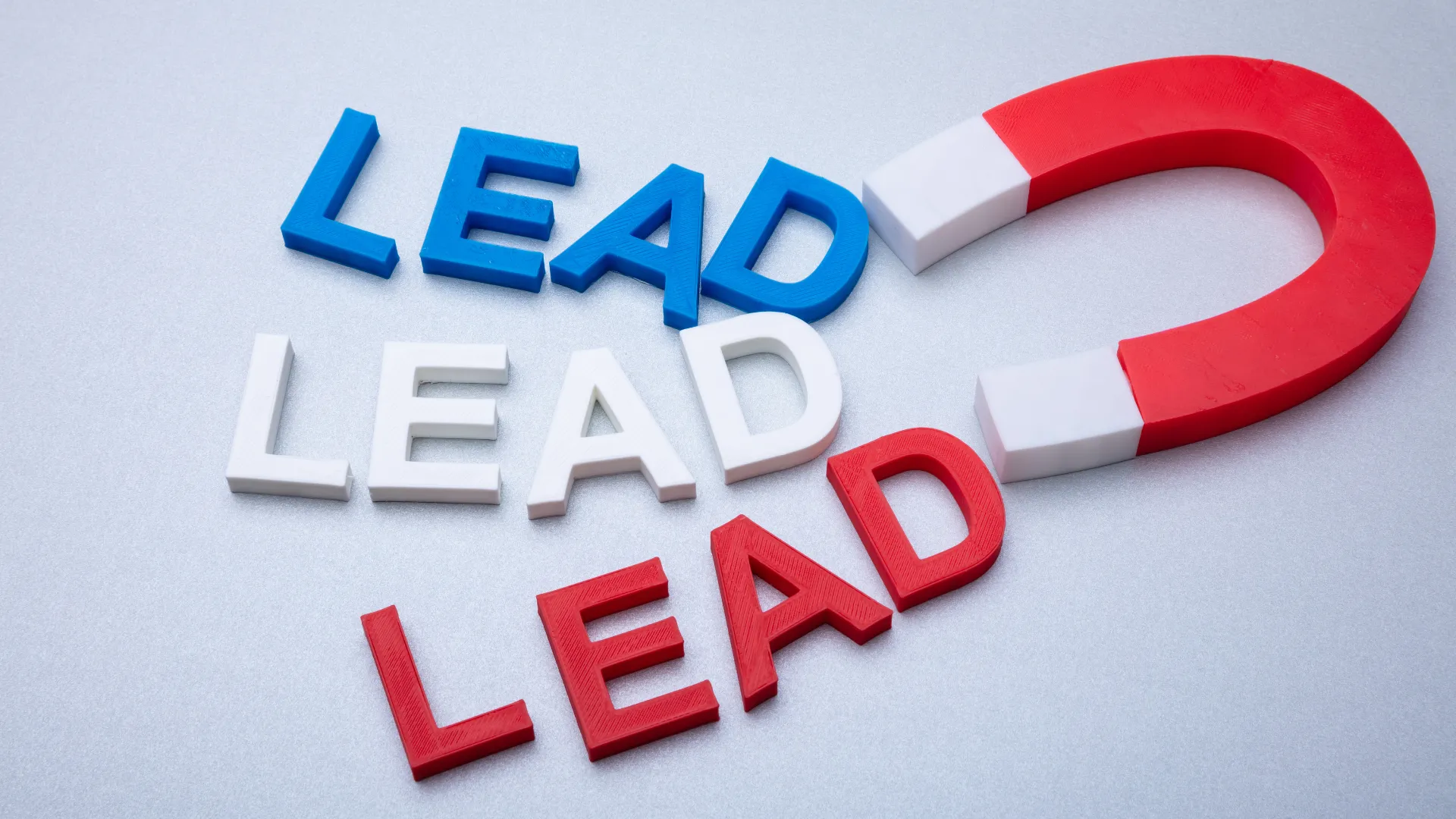 Colorful letters spell LEAD beside a red magnet