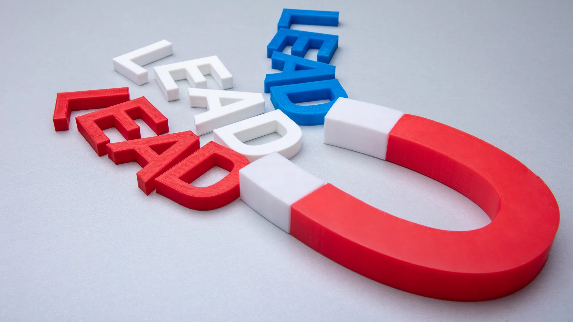 A red magnet pulls colorful letters that spell LEAD