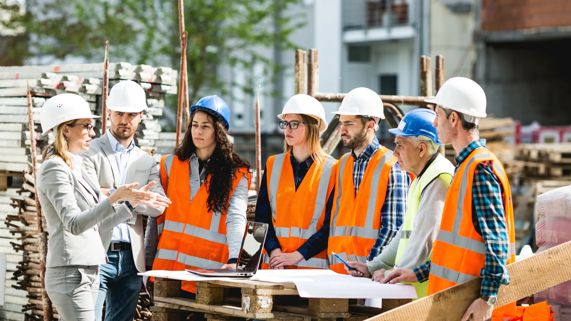 A team in hard hats reviews plans on a construction site
