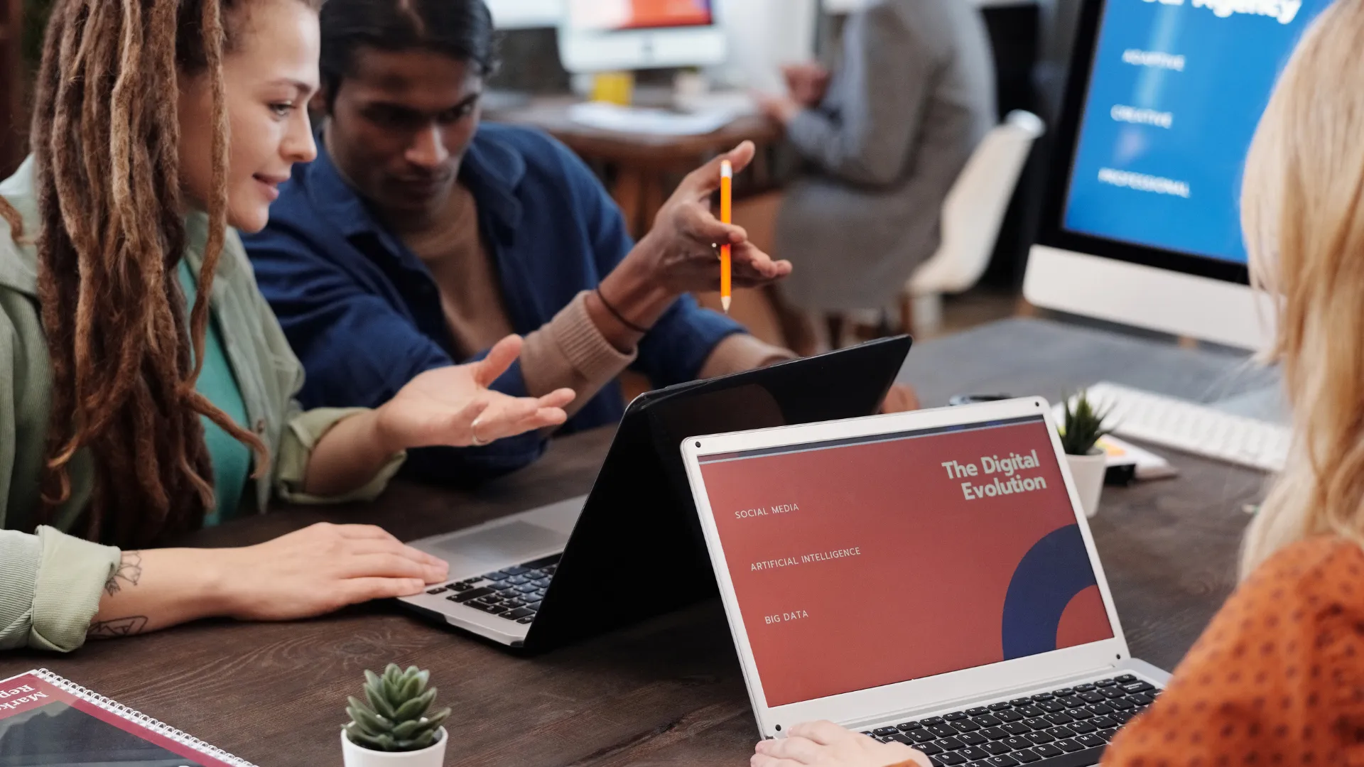 A marketing team reviews a digital campaign on laptops