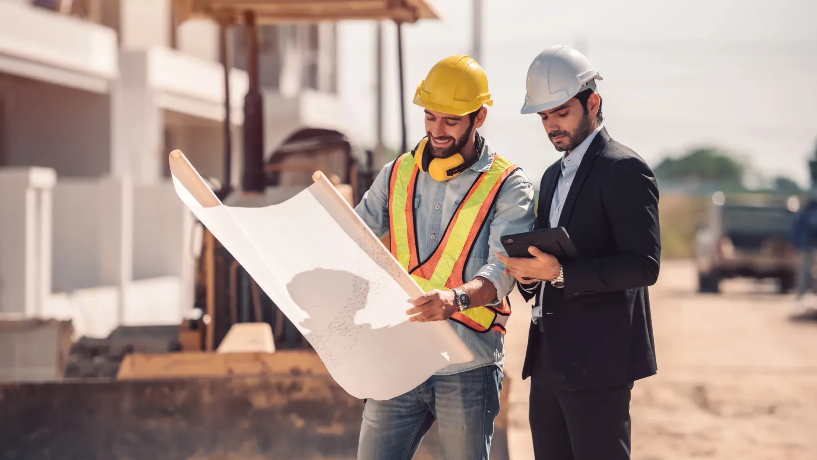 A contractor and a consultant reviewing plans at a job site