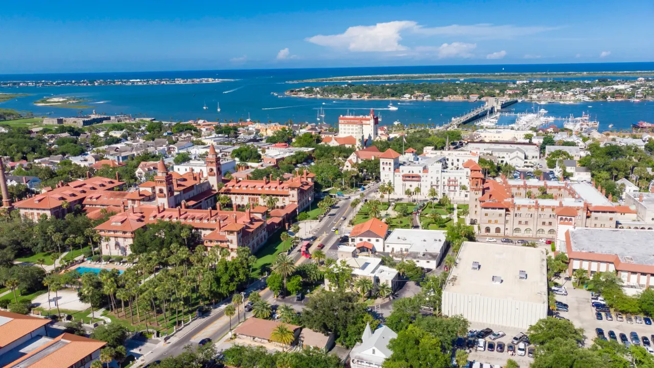 Aerial view of historic downtown St. Augustine with Flagler College, terracotta roofs, and the Matanzas River
