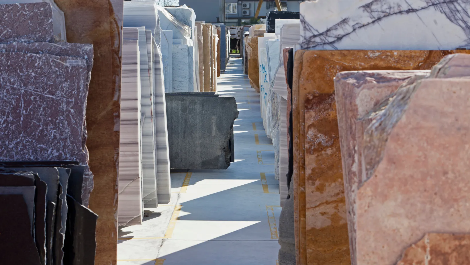 Rows of marble and granite slabs lined up in a stone yard.