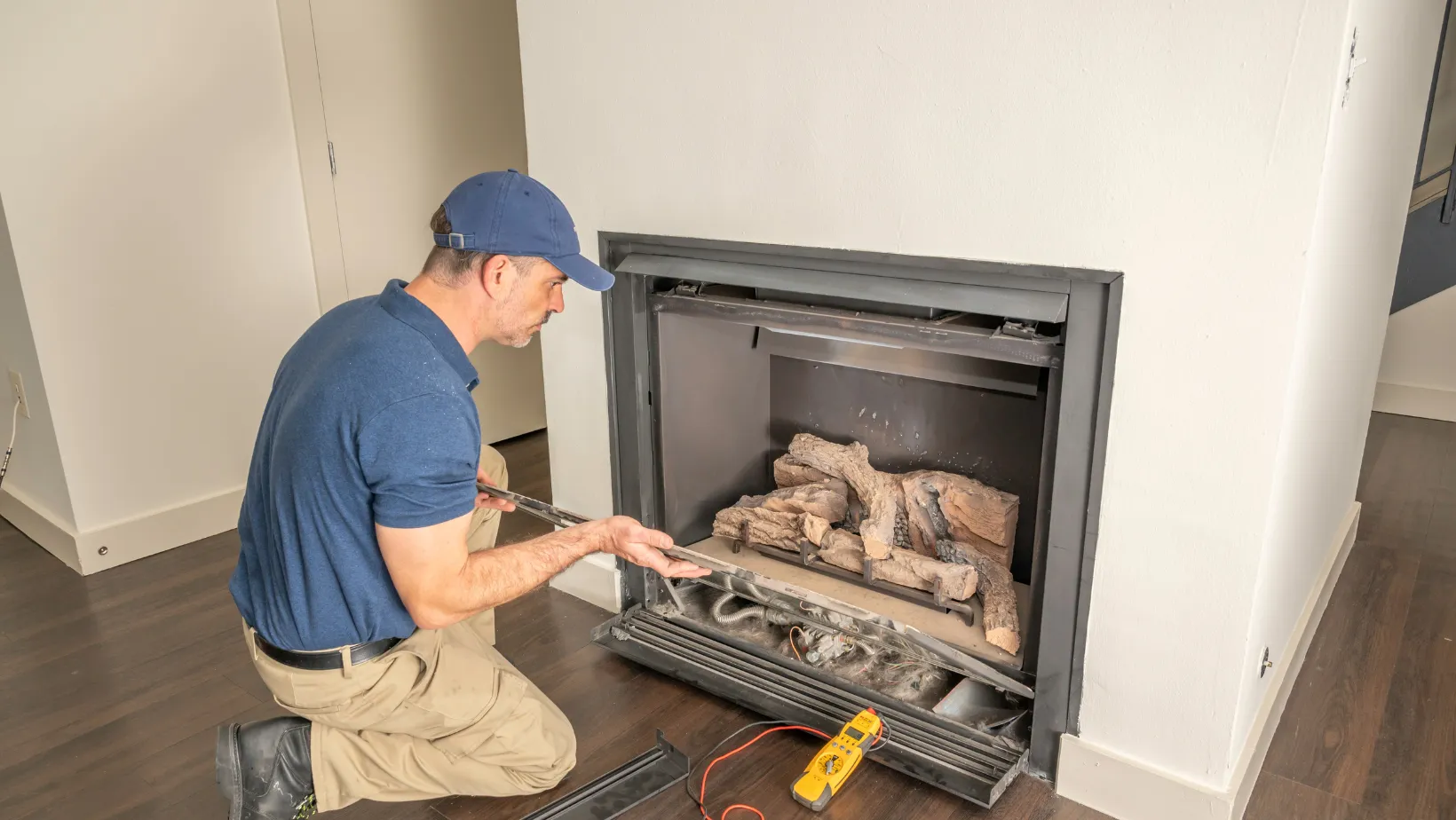 A technician inspecting a gas fireplace insert