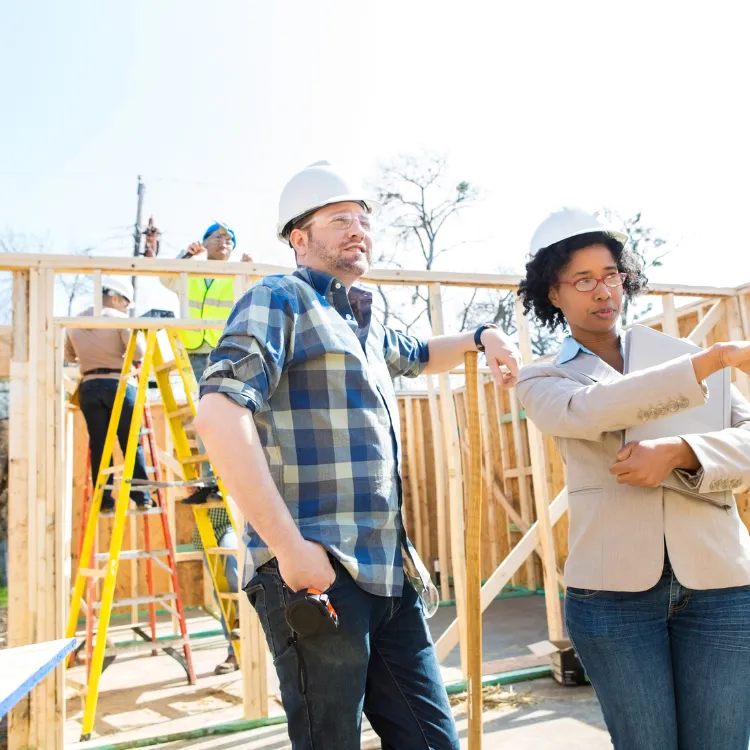 Home builder and project consultant reviewing a residential construction site