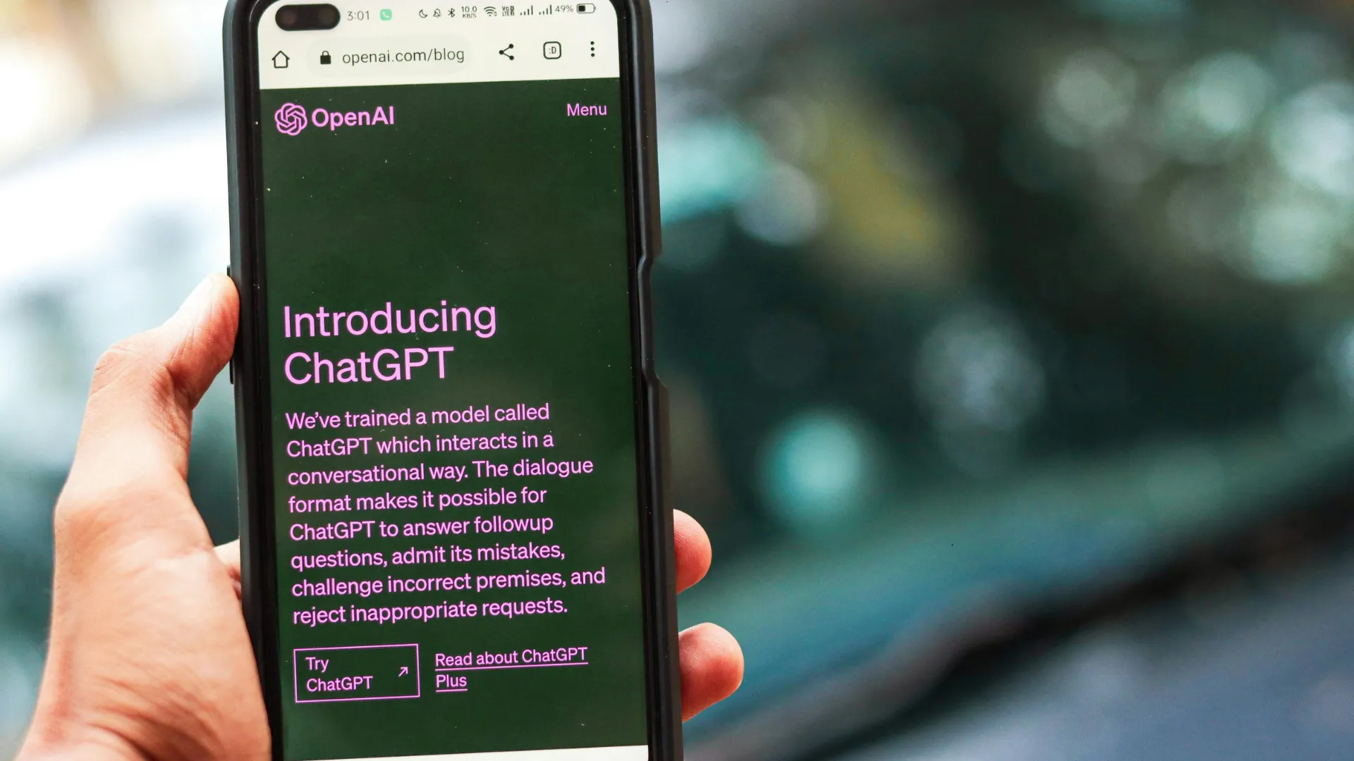 A phone screen shows the Introducing ChatGPT page