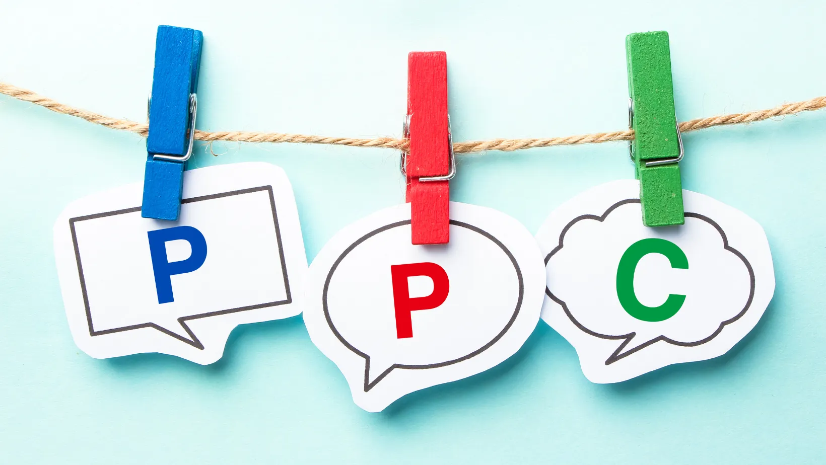 Clothespins holding paper speech bubbles that spell PPC
