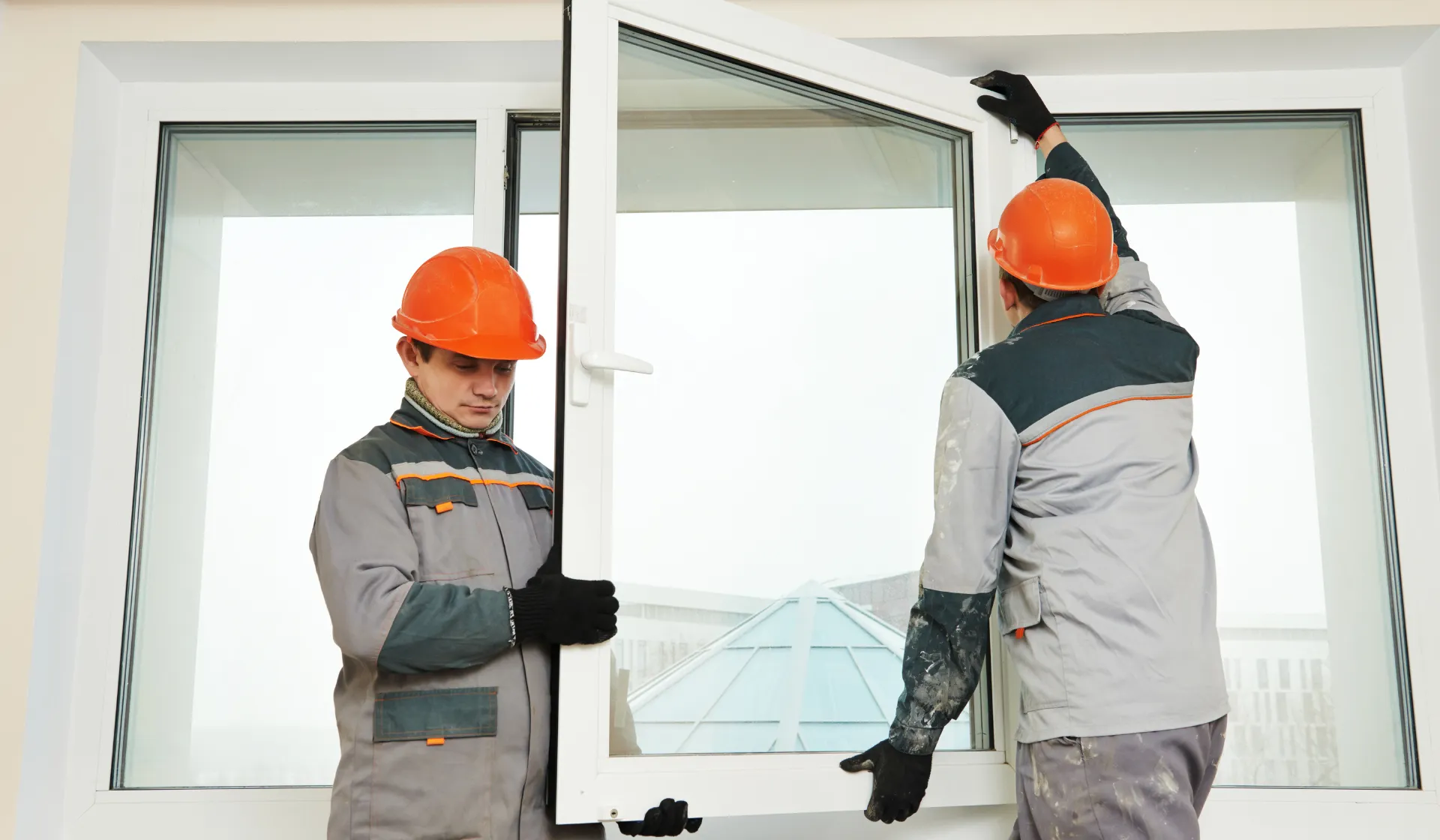 Window and door technicians installing a white-framed window