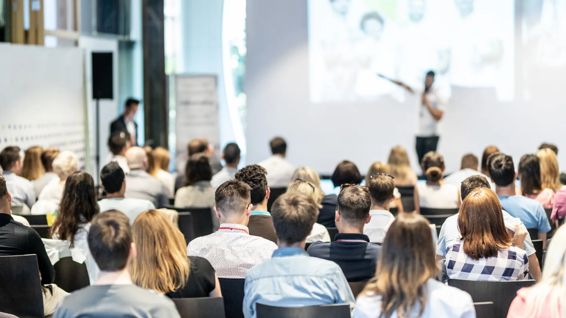 An audience listening to a presentation in a conference room