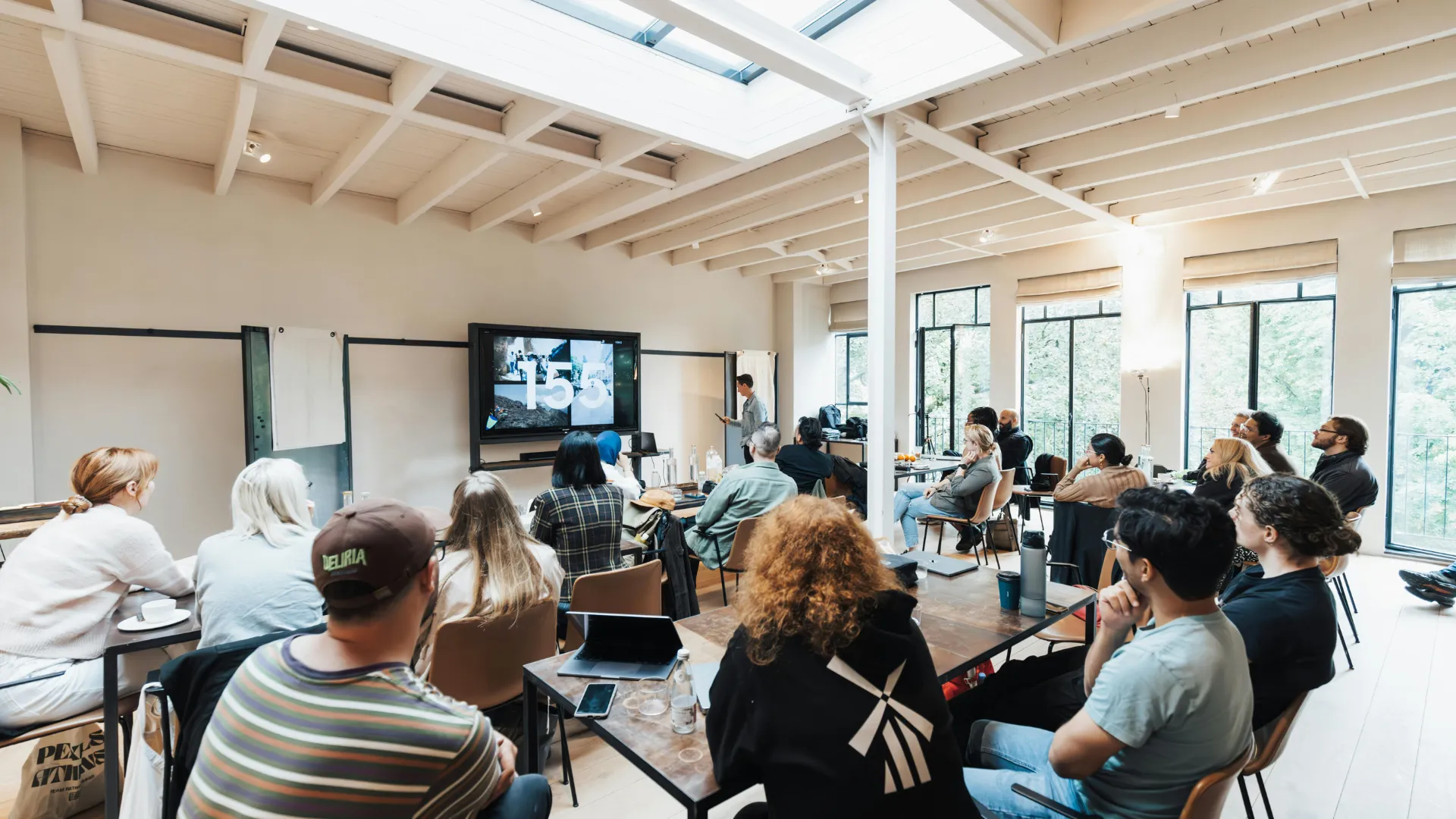 A team in a bright workshop watching a presentation