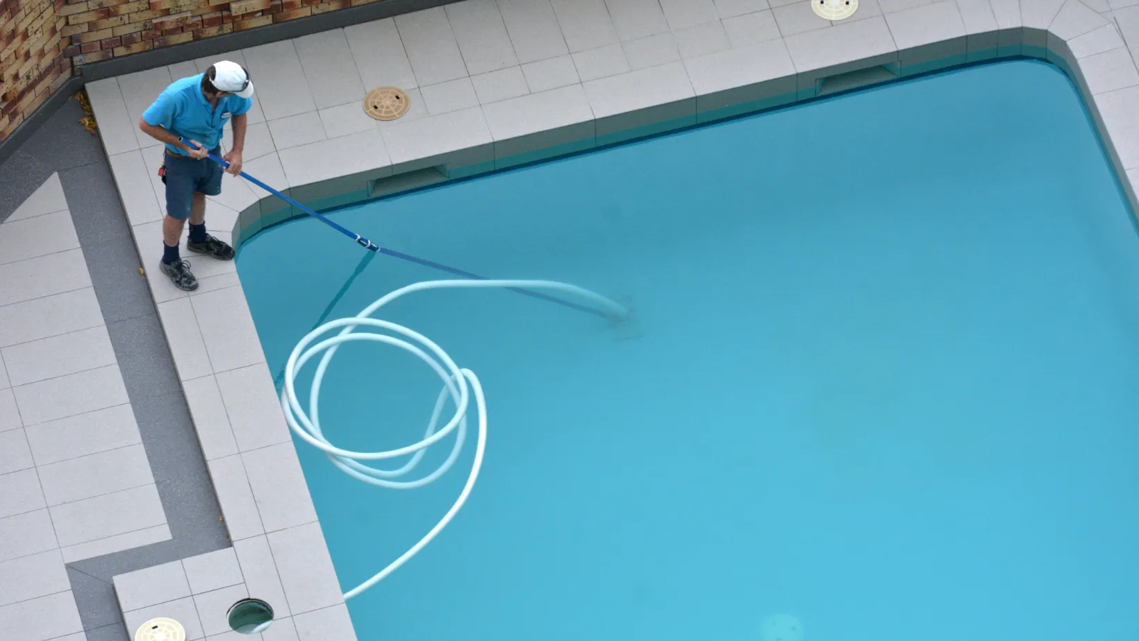 Technician cleaning a swimming pool