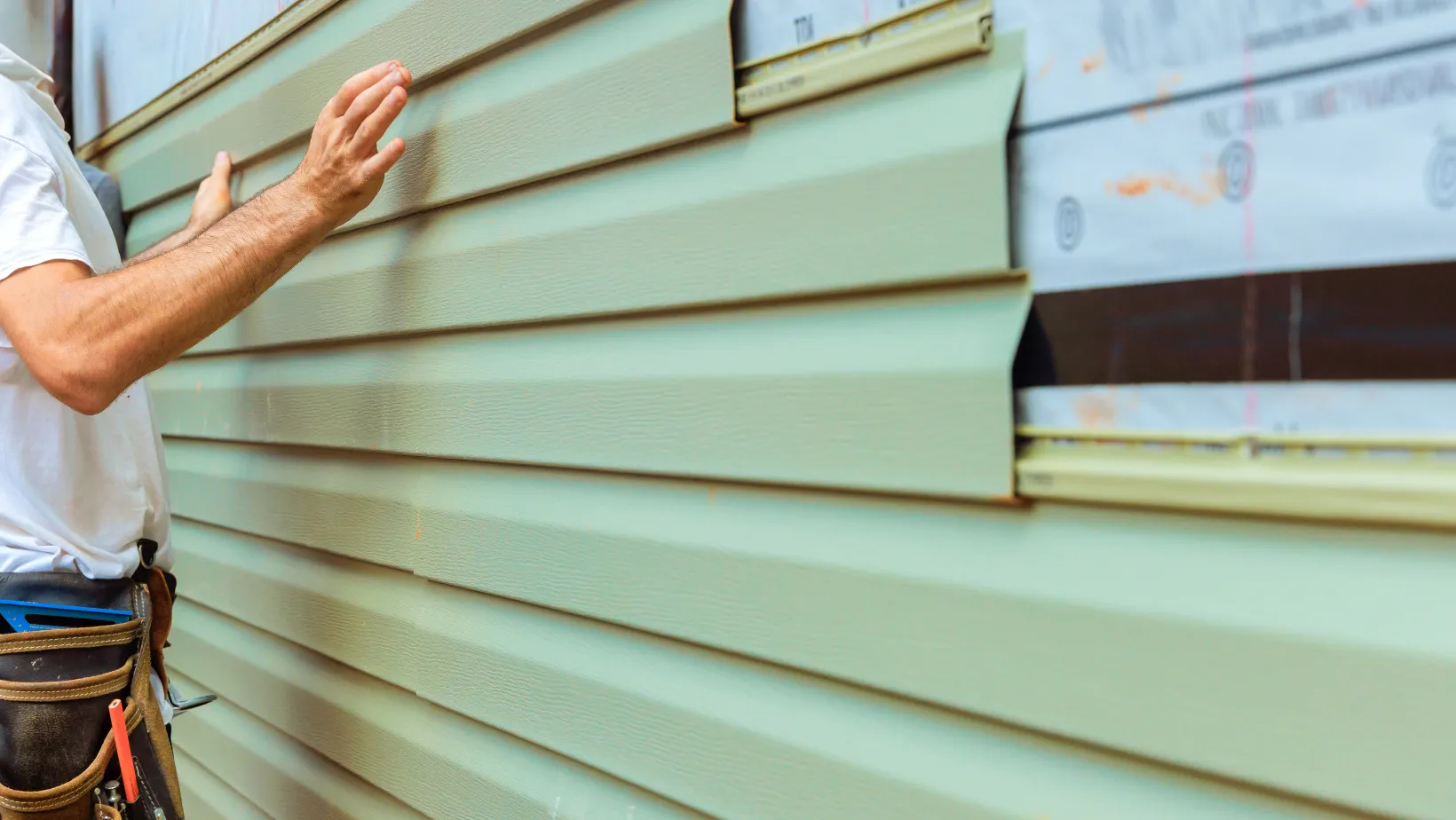 A worker checking newly installed vinyl siding